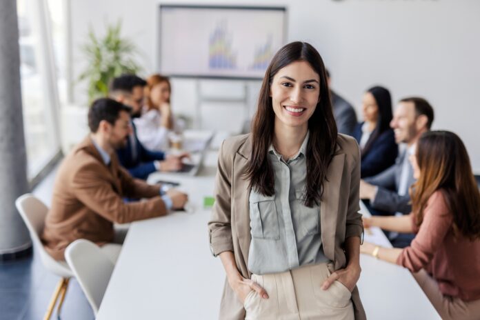Portrait,Of,Smiling,Female,Executive,Standing,In,Conference,Room,During